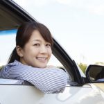 自動車の窓から顔を出す女性