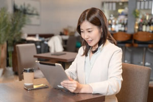 カフェでタブレットを操作する女性