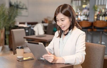 カフェでタブレットを操作する女性