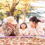 秋の公園でピクニックする家族