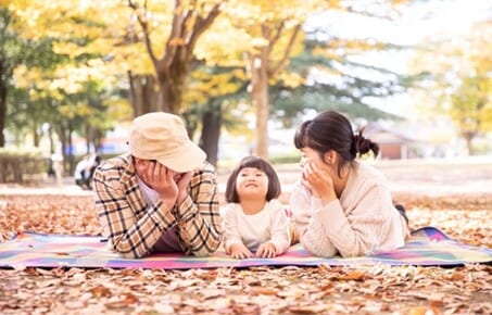 秋の公園でピクニックする家族