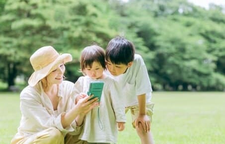 子供と一緒にスマホアプリを使うママ