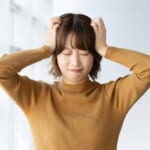 頭を抱えて困る女性