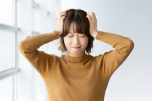 頭を抱えて困る女性
