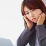 辛そうな表情をしている女性