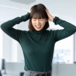 頭を抱えて困る女性