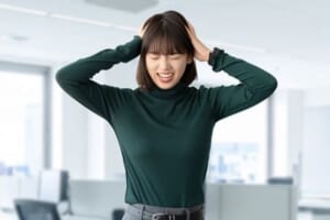 頭を抱えて困る女性