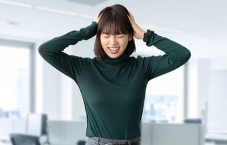 頭を抱えて困る女性