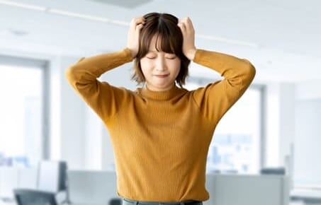 頭を抱えて困る女性