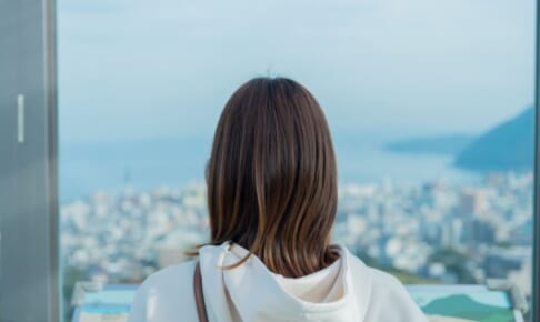 外を眺める女性の後ろ姿