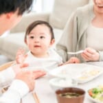 赤ちゃんに離乳食を食べさせる両親