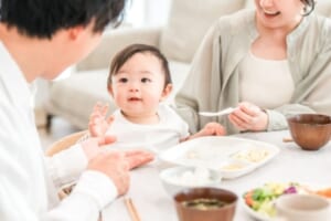 赤ちゃんに離乳食を食べさせる両親