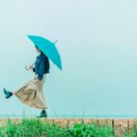 雨の街で傘を差して立つ女性