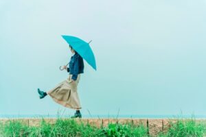 雨の街で傘を差して立つ女性