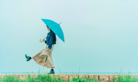 雨の街で傘を差して立つ女性