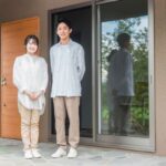 一軒家の前に立つ夫婦