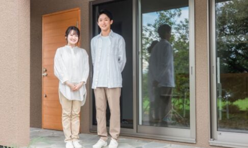 一軒家の前に立つ夫婦
