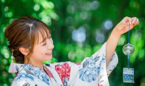 緑の中で風鈴を持つ浴衣姿の日本人女性