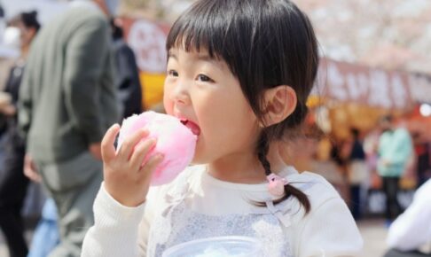 お祭りで綿菓子を食べる子供
